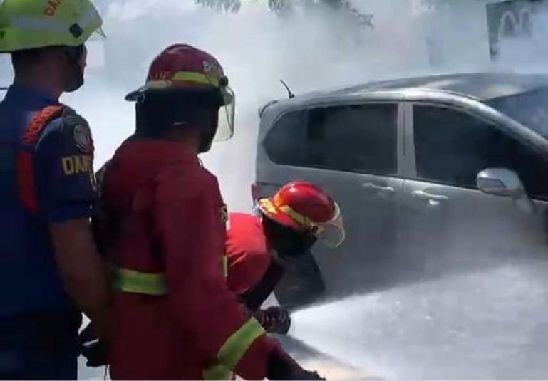 Petugas Damkar Padang berusaha memadamkan api yang membakar satu mini bus di depan gerai Mc Donald's Padang, Jumat (24/7/2026). IST