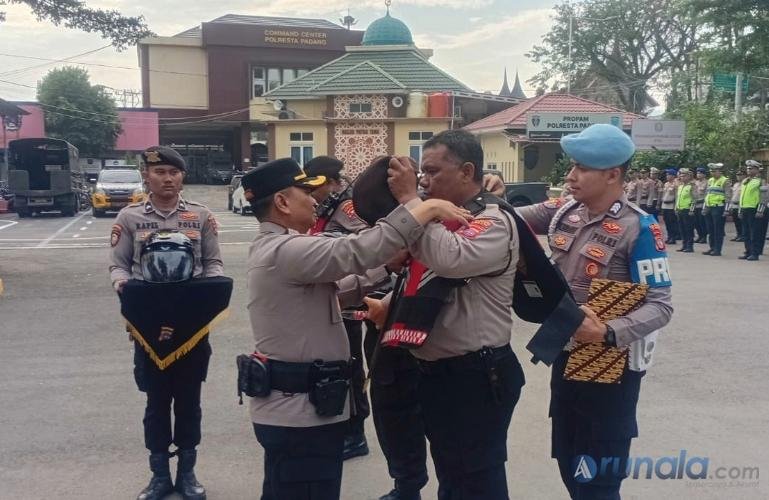 Kombes Pol Apri Wibowo memasangkan rompi kepada salah satu anggota yang akan lakukan Patroli Presisi di Kota Padang, Senin (31/8/2026). (dok: arunala.com)
