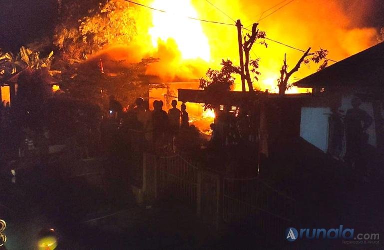 Petugas Damkar dan tim gabungan berusaha memadamkan api yang membakar dua unit rumah di kawasan Piai, Senin (31/8/2026) malam. IST