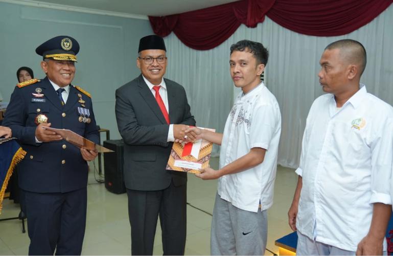 Sekprov Sumbar, Arry Yuswandi didampingi Kakanwil Direktorat Jenderal Pemasyarakatan Sumbar, Kunrat Kasmiri serahkan remisi kepada salah seorang warga binaan, Senin (17/8/2026). IST