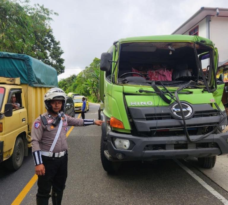 Petugas Lantas Polres Kota Padangpanjang, menunjuk salah satu truk yang terlibat laka beruntun, Sabtu sore (8/8/2026). (dok : Satlantas Polres Kota Padangpanjang)