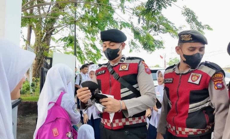 Personel Polresta Padang bagikan masker kepada para siswa guna mencegah terdampak kabut asap akibat kebakaran hutan dan lahan (karhutla), Senin (7/9/2026). IST