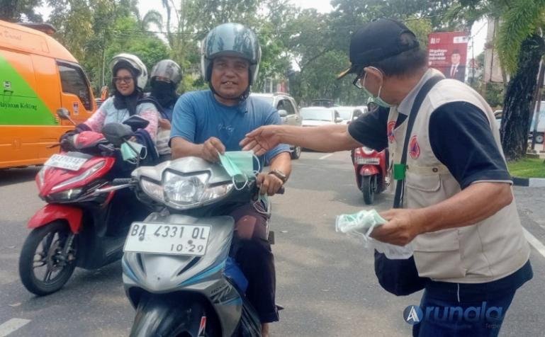 Petugas dari BPBD Kota Padang bagikan masker kepada pengguna jalan sebagai langkah antisipasi kabut asap yang ada di Kota Padang, Senin (7/9/2026). (dok: arunala.com)