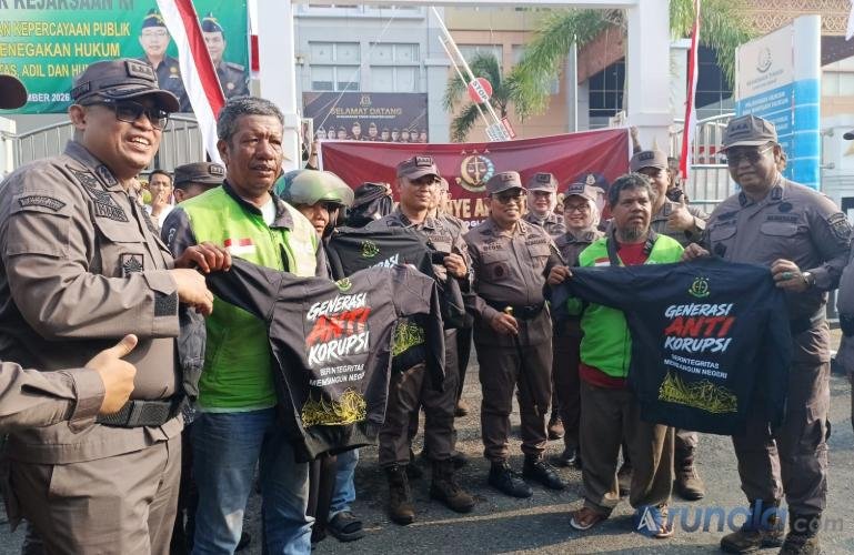 Kajati Sumbar, Dedie Tri Hariyadi bersama pejabat utama di instansi ini serahkan jaket anti korupsi pada pengendara ojek online seusai peringati Hari Jadi Kejaksaan RI, di depan kantor Kejati Sumbar, Padang, Rabu (2/9/2026). (dok: arunala.com)
