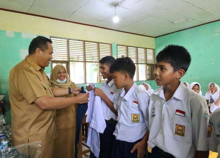 Sejumlah siswa SMPN 7 Kota Pariaman menerima seragam sekolah gratis putih biru yang diserahkan Wali Kota Yota Balad, Senin (14/9/2026). IST