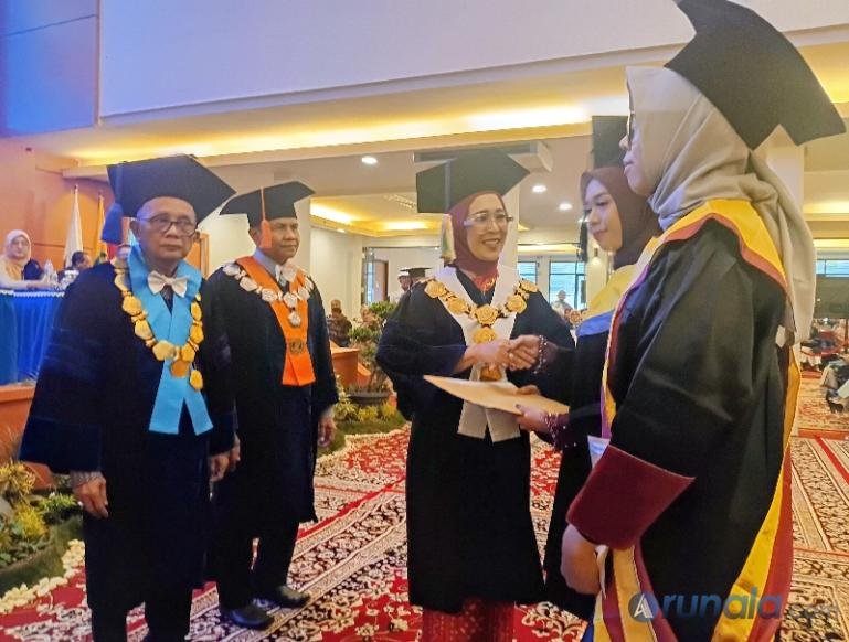 Rektor Universitas Bung Hatta Prof Dr Diana Kartika serahkan piagam penghargaan kepada salah satu lulusan terbaik pada wisuda ke-86 kampus ini, Minggu (25/10/2026). (dok: arunala.com)