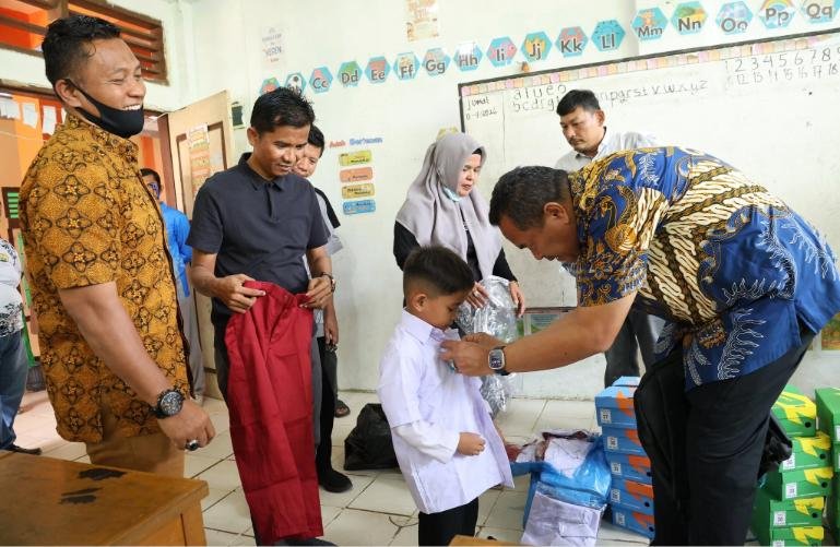 Wali Kota Yota Balad pasangkan seragam sekolah pada salah seorang murid SD yang mendapat banrtuan seragam ini dan buku dari Pemko Pariaman, Jumat (11/9/2026). IST
