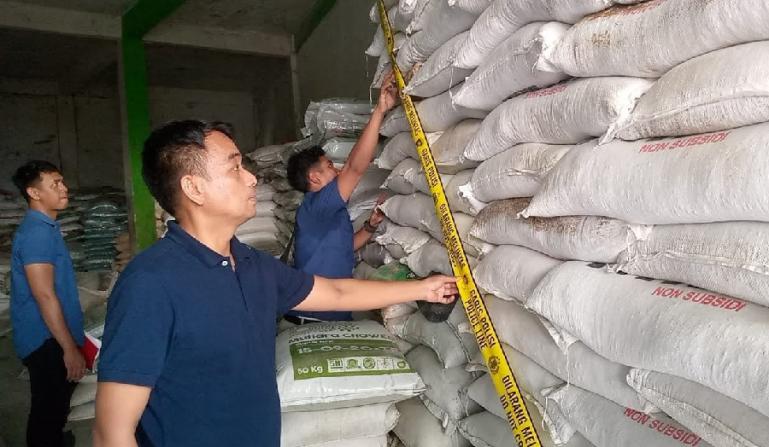 Petugas dari Ditreskrimsus Polda Sumbar sedang memasang garis polisi terhadap ribuan karung pupuk yang diduga palsu dari gudang milik UD TU di Pasbar, Selasa sore (2/5). (Dok : Istimewa)