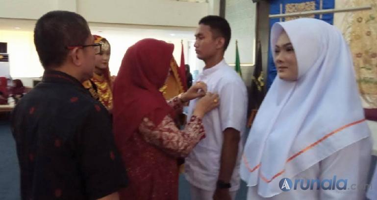 Direktur Poltekkes Kemenkes Padang, Renidayanti didampingi Ketua Jurusan Keperawatan Poltekkes Kemenkes Padang, Tasman pasangkan papan nama pada mahasiswa tanda untuk melakukan praktek di sejumlah rumah sakit, klinik, Puskesmas, Selasa (30/5). (Foto : Derizon)