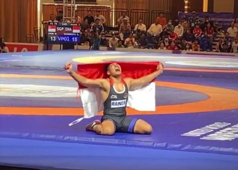 Bripda Randa Rian meluapkan kegembiraannya sambil membawa bendera Merah Putih setelah meraih medali emas cabor gulat nomor freestyle 79 kg putra, di Sea Games 2023 Kamboja, Selasa (16/5). (Dok : Istimewa)